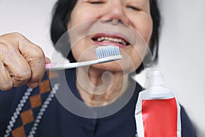 Asian elderly woman trying use toothbrush. Dental