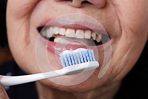 Asian elderly woman trying use toothbrush ,hand tremor photo