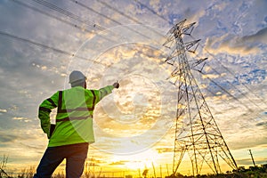 Asian electrical engineer standing and watching at the electric power station to view the planning work by producing electricity