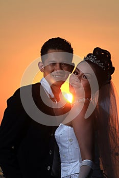 Asian elegance wedding couple ourdoor with sunset backgound photo