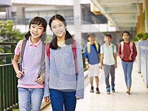 Asian elementary school girls walking in the hallway