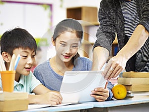 Asian elementary schoolchildren using digital tablet