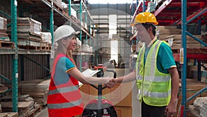 Asian employee or worker shake hands to employer man for greeting, dealing, teamwork, in warehouse. woman and man engineer wearing