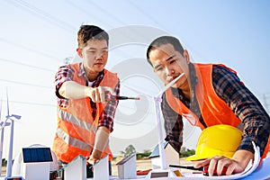 Asian engineer, foreman or leader discussion about home solar cell and wind turbine model in construction site project and High