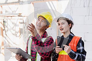 Asian engineer foreman worker man and woman working at building construction site