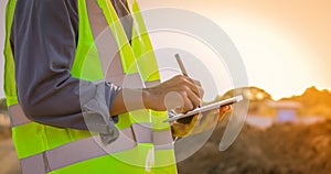 Asian engineer with hardhat using tablet pc computer inspecting