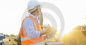 Asian engineer with hardhat using tablet pc computer inspecting