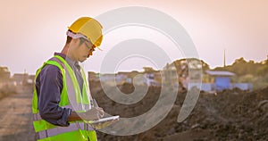 Asian engineer with hardhat using tablet pc computer inspecting