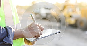 Asian engineer with hardhat using tablet pc computer inspecting