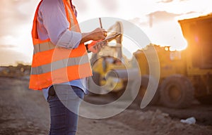 Asian engineer with hardhat using tablet pc computer inspecting