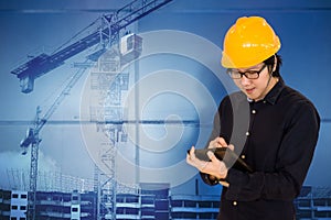 Asian engineer holding tablet at construction site
