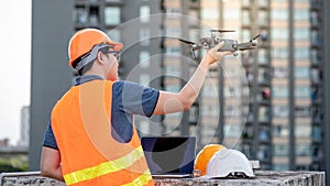 Asian engineer man using drone and laptop for construction site