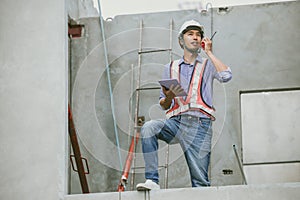 Asian engineer overseeing construction project at construction site, Professional builder working