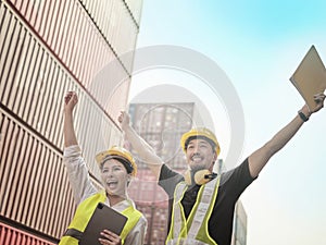 Asian engineer raise their hands up cheering for their victory