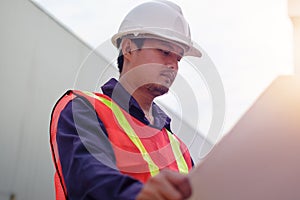 Asian engineer in safety uniform holding project plan