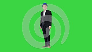Asian engineer in a suit and hardhat standing with hands folded on a Green Screen, Chroma Key.