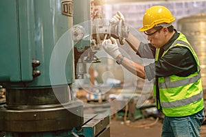 Asian engineer technician worker wearing safety suit helmet eyes protection focus manual skill control machine production process