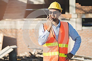 Asian engineer using radio to command to labour team in site construction