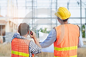 Asian engineer using radio to command to labour team in site construction