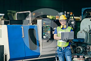 Asian engineer working programming the machine in factory with laptop computer to setup program process, Portrait looking camera