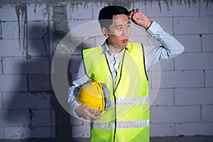 Asian Engineering man with safety helmet feeling Exhausted due to overworking in construction site