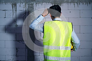 Asian Engineering man with safety helmet feeling Exhausted due to overworking in construction site