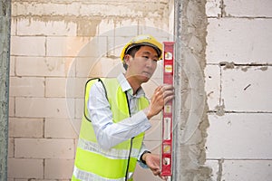 Asian Engineering man wearing safety helmet checking construction site analyzing about project progress