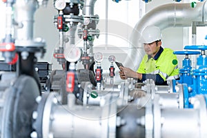 Asian engineers inspect and maintain condenser equipment. Water supply pumps in substations for distributing clean water at