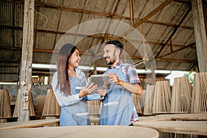 Asian enterpreneur couple chatting while working on a tablet together