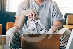Asian entrepreneur teenager is carrying baby shoes and put in a cardboard box customer to deliver the product at home