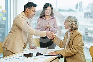 Asian entrepreneurs handshakes to congratulate the agreement between the two companies to enhance investment and