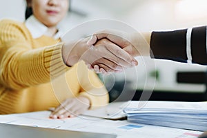 Asian entrepreneurs handshakes to congratulate the agreement between the two companies to enhance investment and