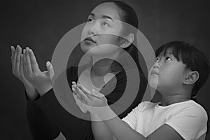 Asian face woman and child praying and worship to GOD Using hands to pray in religious beliefs and worship christian in the church