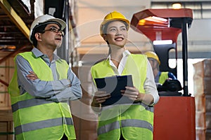 Asian factory manager and engineer woman working in warehouse.