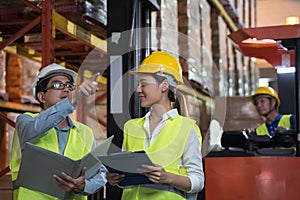 Asian factory manager and engineer woman working in warehouse.