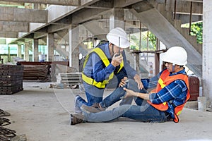 Asian factory worker having accident while working in manufacturing site while his colleague is helping for safety workplace and