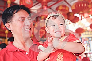Asian family celebrating Chinese new year, Cute little 2 years old toddler boy child in traditional red Chinese suit at local Chin