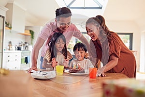 Asian Family Celebrating Sons Birthday At Home Surprising Him With Candle Covered Cake