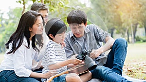 Asian family come for picnic at the park. There are father, mother, son and grandmother.