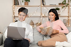 Asian Family Couple Relaxing With Laptop And Book At Home