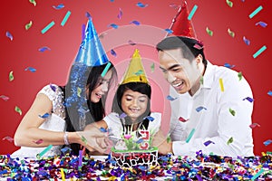 Asian family cutting a birthday cake