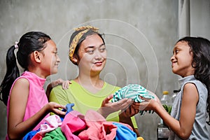 Asian Family Domestic Lifestyle. Stay at Home Mother Happy Doing Laundry Accompanied by Her Children