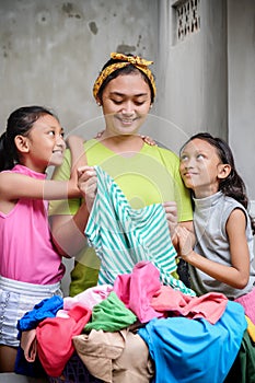 Asian Family Domestic Lifestyle. Stay at Home Mother Happy Doing Laundry Accompanied by Her Children