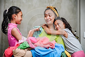 Asian Family Domestic Lifestyle. Stay at Home Mother Happy Doing Laundry Accompanied by Her Children