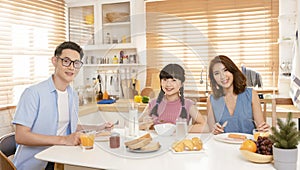 Asian family enjoy eating breakfast together in kitchen room at home