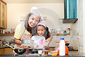 Asian family enjoy making pancake, Asian mother and daughter enjoy making bakery cake, Little Asian girl and mom enjoy decorate p