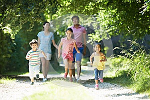 Asian Family Enjoying Walk In Countryside