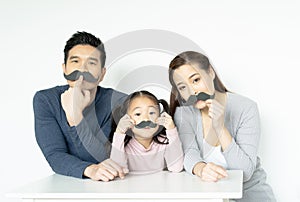 Asian family with fake mustache. Happy family playing in home. Family holidays and togetherness