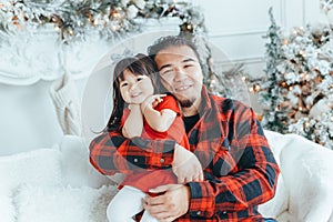 Asian family father dad hugging with daughter toddler girl celebrating Christmas or New Year at home