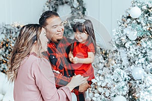 Asian family father, mother with daughter toddler girl celebrating Christmas or New Year at home